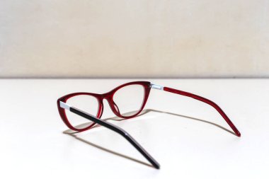 Kırmızı ve siyah gözlük beyaz arka plana yerleştirilmiş ve fotokopi alanı var. Görme bozukluğu olan insanların görme duyusunu düzeltmek için kullanılan optik aksesuar