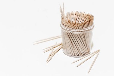 Beyaz arka planda plastik şeffaf kutuda tahta kürdanlar ve kopyalama alanı. Yiyecek artıklarını temizlemek için kullanılan küçük bir diş hijyeni.