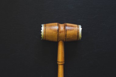 Siyah arka planda metalik kenarları olan büyük tahta et çekici. Taştan döşeme tahtası üzerinde el yapımı bir mutfak aracı