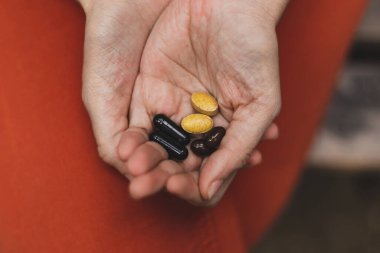 İlaç hapları ve vitaminler tutan eller. Bir kadının avuçlarında ilaç ürünleri