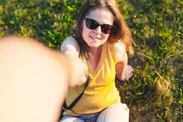 Усміхнена Жінка Сидить Траві Виходить Допомогу Щаслива Дівчина Сонцезахисних Окулярах — стокове фото