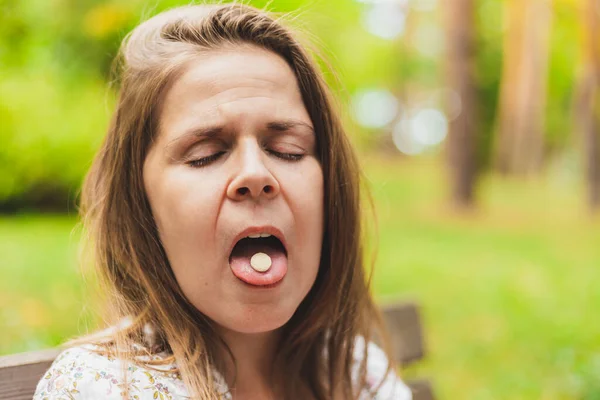 Mujer Joven Sosteniendo Píldora Blanca Lengua Aire Libre Muchacha Bastante —  Fotos de Stock