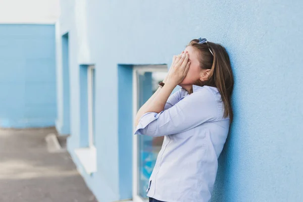 Sad Person Laying Blue Building Exterior Wall Hands Her Face — Stock Photo, Image