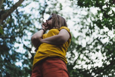 Bulanık bir geçmişi olan, dışarıda parkta duran düşünceli genç bir kadın. Sıradan giyinmiş kız kollarını çapraz tutarken düşüncelerinde kaybolmuş. Uzakta hayal kuran bir kadın.