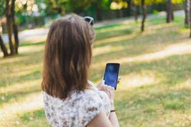 Akıllı telefon kullanan bir kadın. Elle dokunulan bir ekrana yakın. Elinde boş bir ekranla elinde telefon tutan bir kız.
