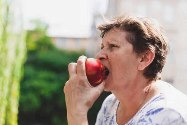 Прекрасный Портрет Пожилой Женщины Поедающей Красное Яблоко Улице Летний День — стоковое фото