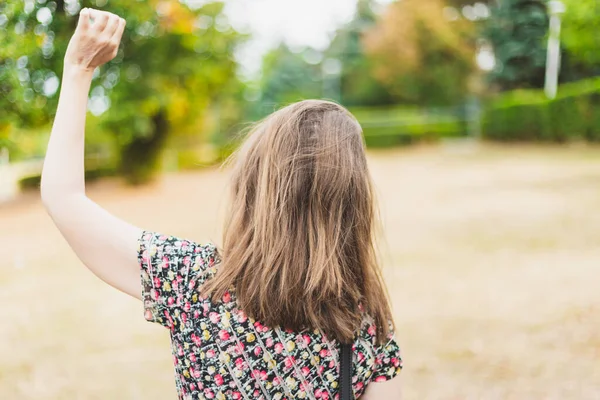 晴れた日に公園でお別れを振っている若い女性 時折服を着た女の子がハローや別れの手のジェスチャーを作る 女性は片手で優しい挨拶をする — ストック写真