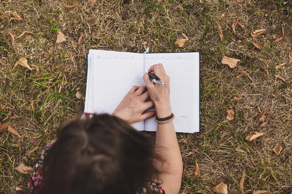 Estudiante Tomando Notas Con Bolígrafo Pequeño Cuaderno Mientras Está Sentado —  Fotos de Stock