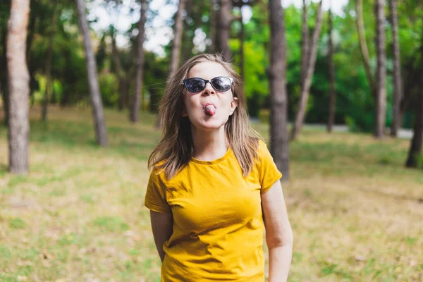 Грайлива Красива Молода Жінка Показує Язик Сидячи Сонці Парку Щаслива — стокове фото