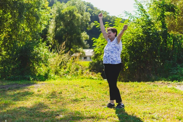夏の日に外で踊る幸せなシニア女性かわいいおばあさんはリラックスして自然に良い感じ ライフスタイルのコンセプトイメージ — ストック写真