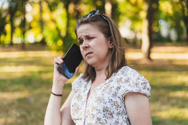 在外面用手机说话的年轻女人皱着眉头 怒气冲冲的棕色头发的女孩在电话里粗野地交谈 — 图库照片