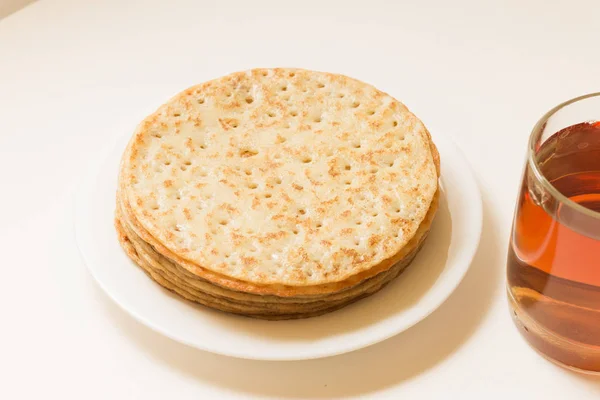 Krep yerken üzerine beyaz bir tabak ve bir fincan çay