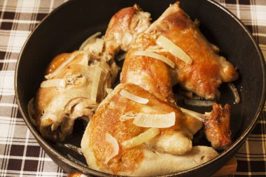 Soğan bir tavada kızarmış tavuk.