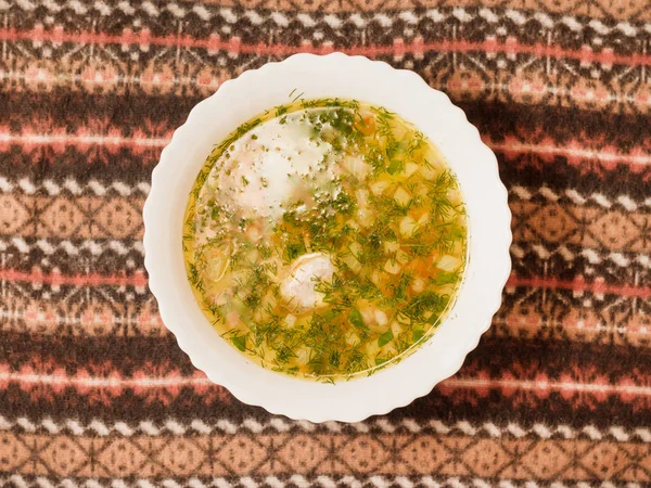 Üstten görünüm beyaz bir kapta Tavuk sakatat çorbası.