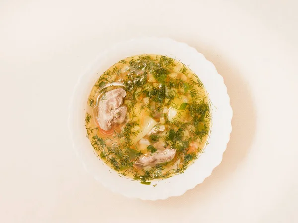 Üstten görünüm beyaz bir kapta Tavuk sakatat çorbası.