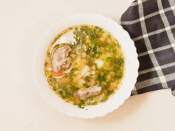 Üstten görünüm beyaz bir kapta Tavuk sakatat çorbası.