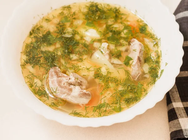 Üstten görünüm beyaz bir kapta Tavuk sakatat çorbası.