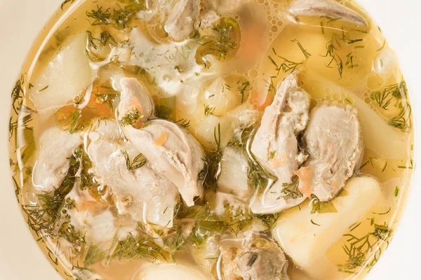 Tavuk sakatat ve beyaz kase yakın çekim sebze çorbası. Üstten görünüm.