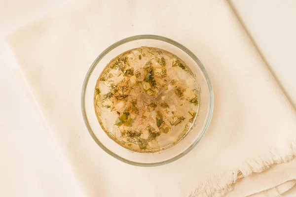 Şeffaf bir kase Tavuk sakatat çorbası. Üstten görünüm.