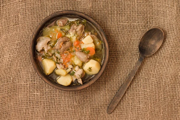 Tavuk sakatat ve ahşap kase sebze çorbası. Üstten görünüm.