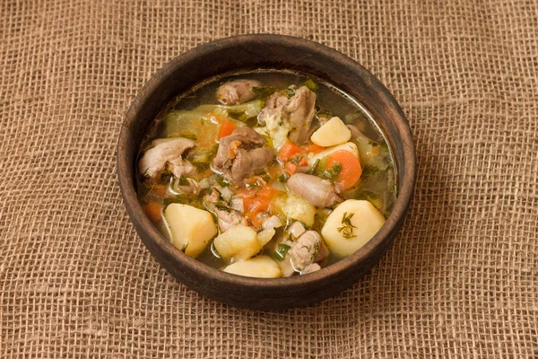 Tavuk sakatat ve ahşap kase sebze çorbası. Üstten görünüm.