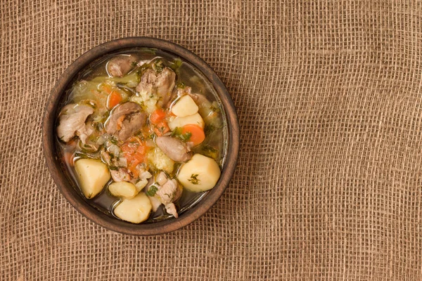 Tavuk sakatat ve ahşap kase sebze çorbası. Üstten görünüm.