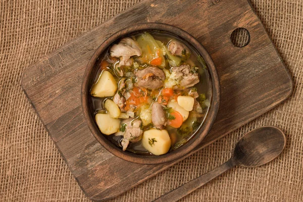 Tavuk sakatat ve ahşap kase sebze çorbası. Üstten görünüm.