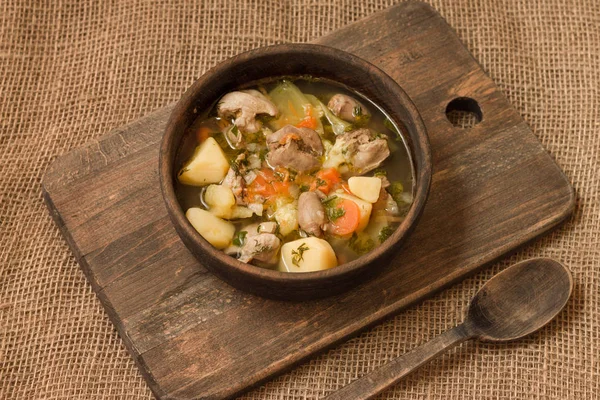 Tavuk sakatat ve ahşap kase sebze çorbası. Üstten görünüm.