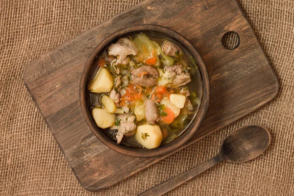 Tavuk sakatat ve ahşap kase sebze çorbası. Üstten görünüm.