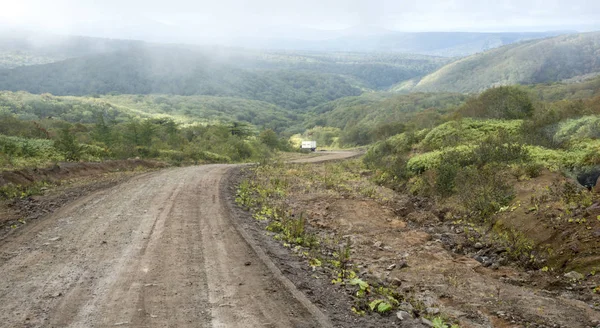 Toprak yol yaz tepelerde arasında.
