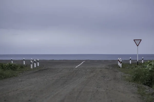 Geniş bir alana doğru toprak bir yol. Dağ yolu ve gökyüzü.