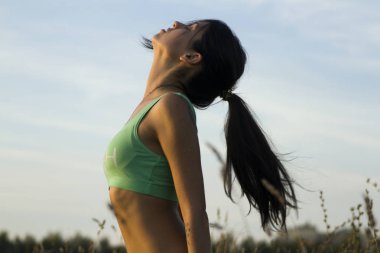 sporcumuz gökyüzüne karşı portresi. Yoga yaparken genç kız