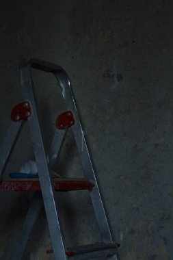 Gri duvar arka plan üzerinde bir merdiven. Ev ya da yazıhane onarmak.