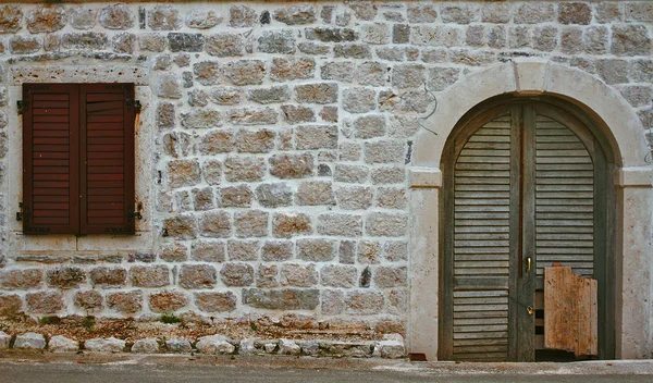 Kapı ve kepenkli eski taş duvar — Stok fotoğraf