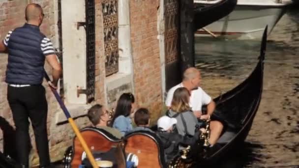 ヴェネツィア、イタリア- 2017年10月7日:ゴンドラは建物をキックオフし、観光客に乗る. — ストック動画