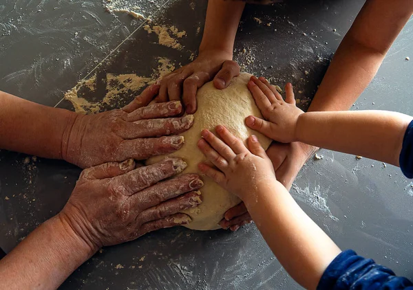 Three pairs of hands holding the dough — Stock Photo, Image