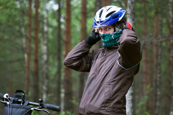 Young man wearing bicycle helmet and face mask to protect himself from coronavirus.