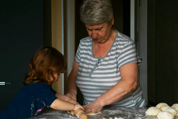 Grandma and granddaughter roll out the pie dough. — Stock Photo, Image