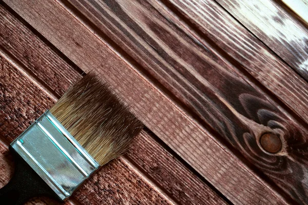 Der Pinsel liegt auf einer offenen weißen Farbdose. Der Blick von oben. Komposition auf hellgelbem Holzgrund. — Stockfoto