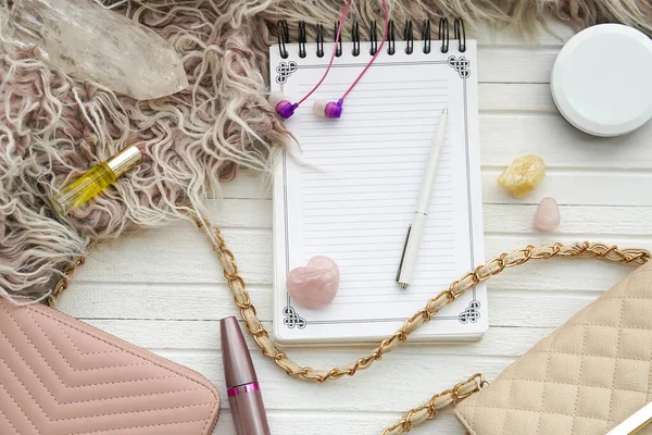 Women\'s flatlay with notebook, handbag, cosmetics, cristall and minerals. Concept of wellbeing and mental health using spiritual therapy and power of stones.