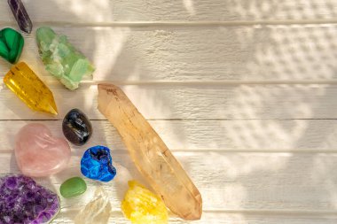 Beyaz ahşap arka planda farklı mineral ve kristaller var.
