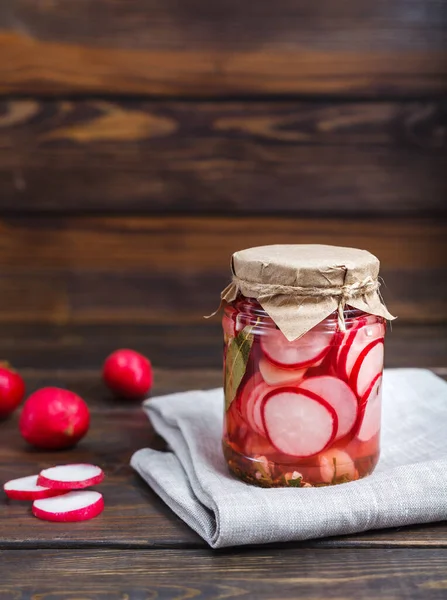 Hausgemachter eingelegter Rettich in einem Glas auf dunklem Holzgrund, Kopierraum — Stockfoto