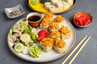 Yuvarlak tabakta rulo ve sebze salatası