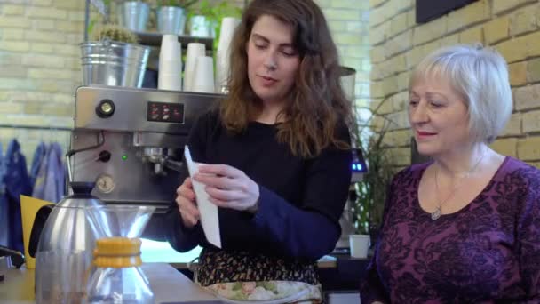 Barista vertelt volwassen vrouw over koffiefilters en hoe het te gebruiken — Stockvideo