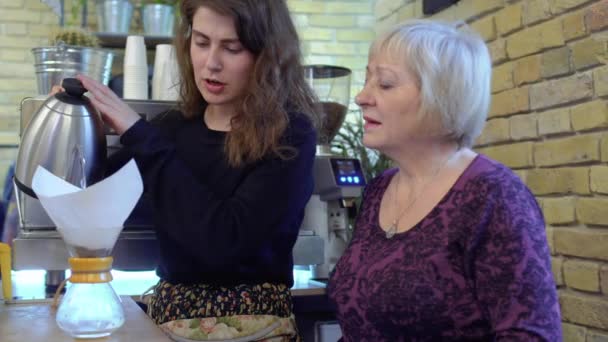 Barista versez de l'eau chaude à l'intérieur de la cruche en verre avec café — Video