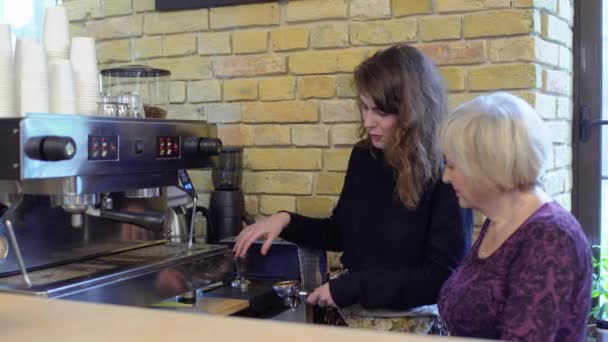 Бариста учит бабушку пользоваться портативным фильтром и кофеваркой — стоковое видео