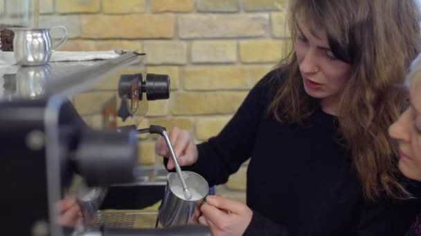 Barista ukazují zralá žena, jak mést kávu horkou párou — Stock video