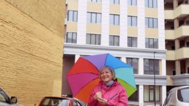 Renkli umbrells ile kadın kıdemli Street biriyle tanışmak