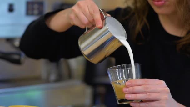 Barista gießen heiße Milch in einen Kaffee — Stockvideo