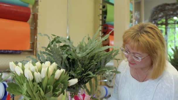 Volwassen vrouw Kies bloemen in bloemenwinkel — Stockvideo